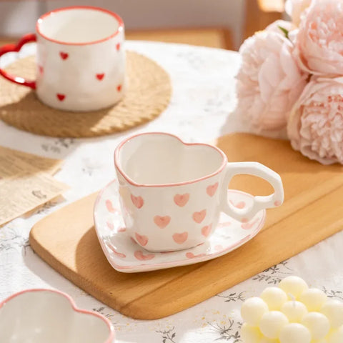 White heart-shaped cup and saucer with pink heart pattern